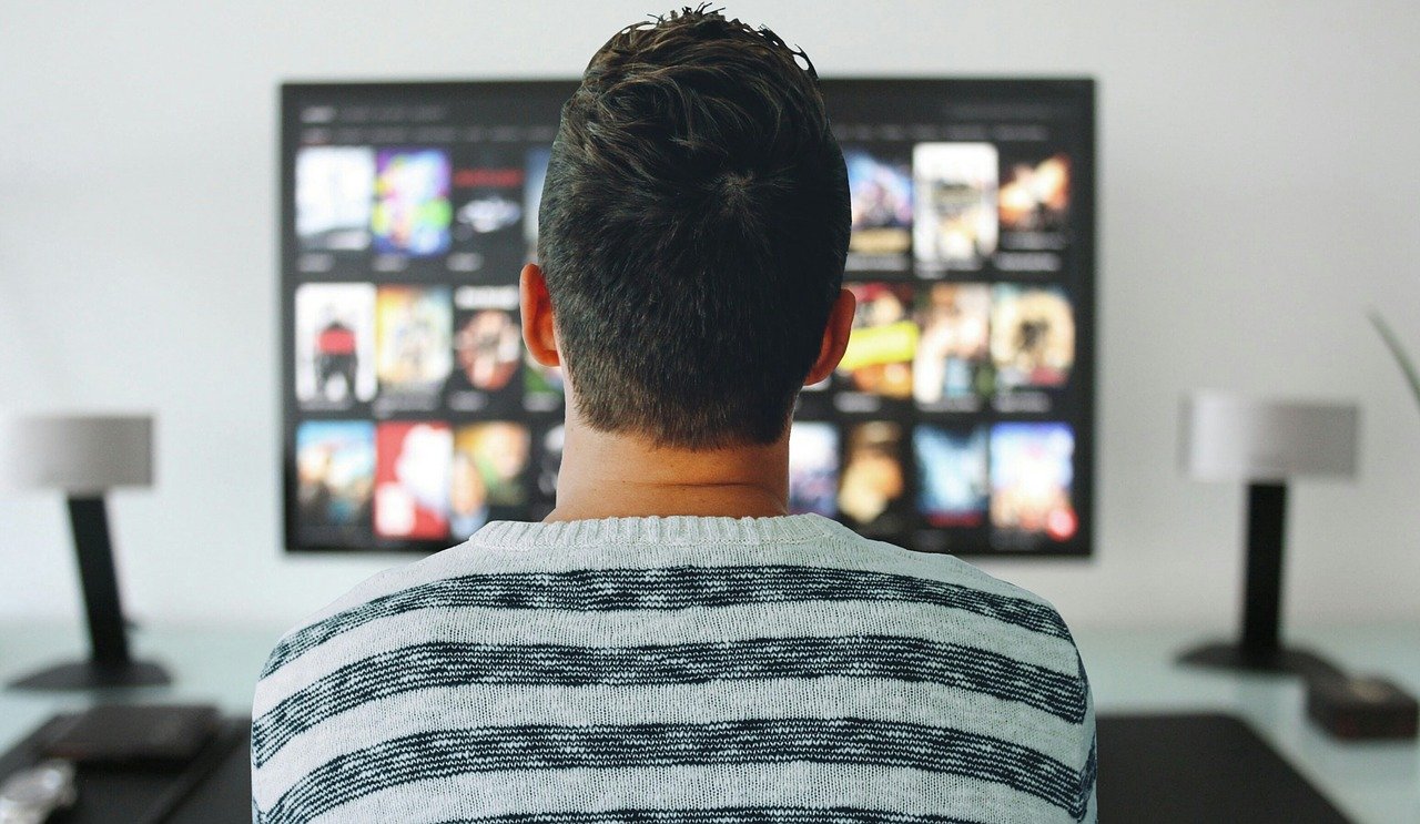 The back of a man watching TV