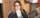 Woman with wavy hair and glasses smiles for camera