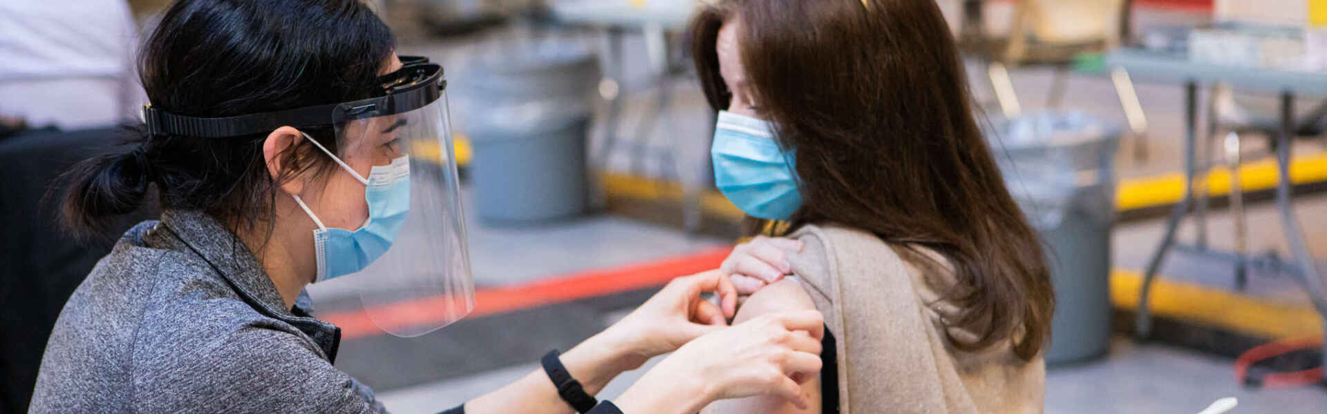 A person receives a COVID-19 vaccination from a health care worker