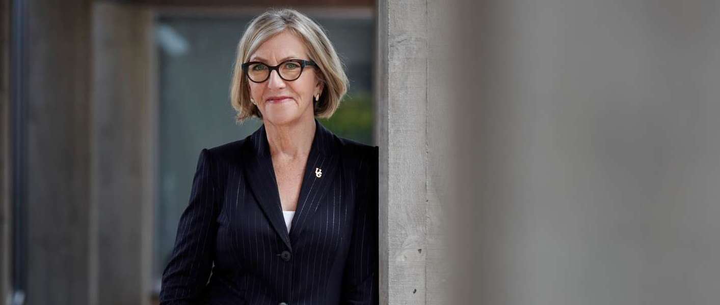 Dr. Charlotte Yates leans against a concrete wall