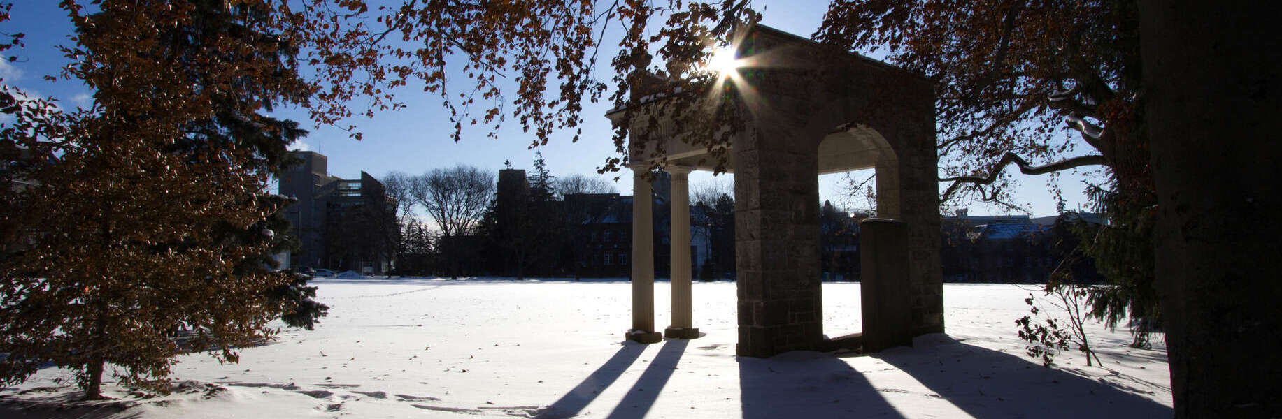 A silhouette of the portico on the U of G campus in winter as the sun sets behind it