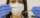 woman in white shirt holding blue plastic spoon