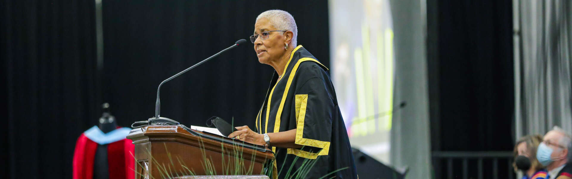 Dr. Mary Anne Chambers stands at podium speaking at 2022 convocation.