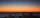 A bright orange sunrise over SO's La Silla Observatory in northern Chile. In the centre of the sky are three shiny lights: Jupiter (top), Venus (lower left), and Mercury (lower right) forming a triangle.