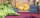 Crates of bananas and grapefruit sit on a tablecoth-covered table