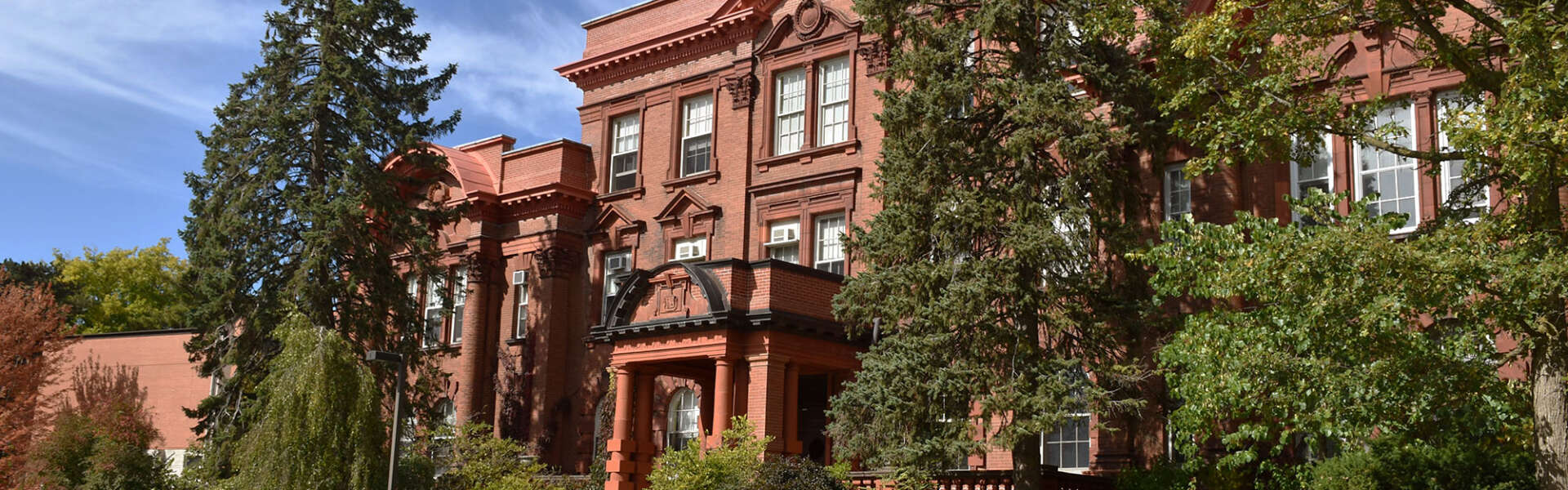A red brick building with a green lawn in front of it,