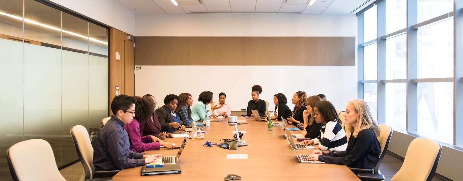 people having meeting on rectangular brown table