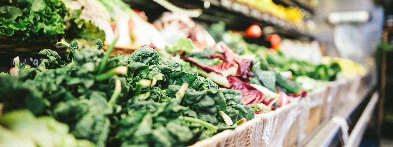 row of vegetables placed on multilayered display fridge