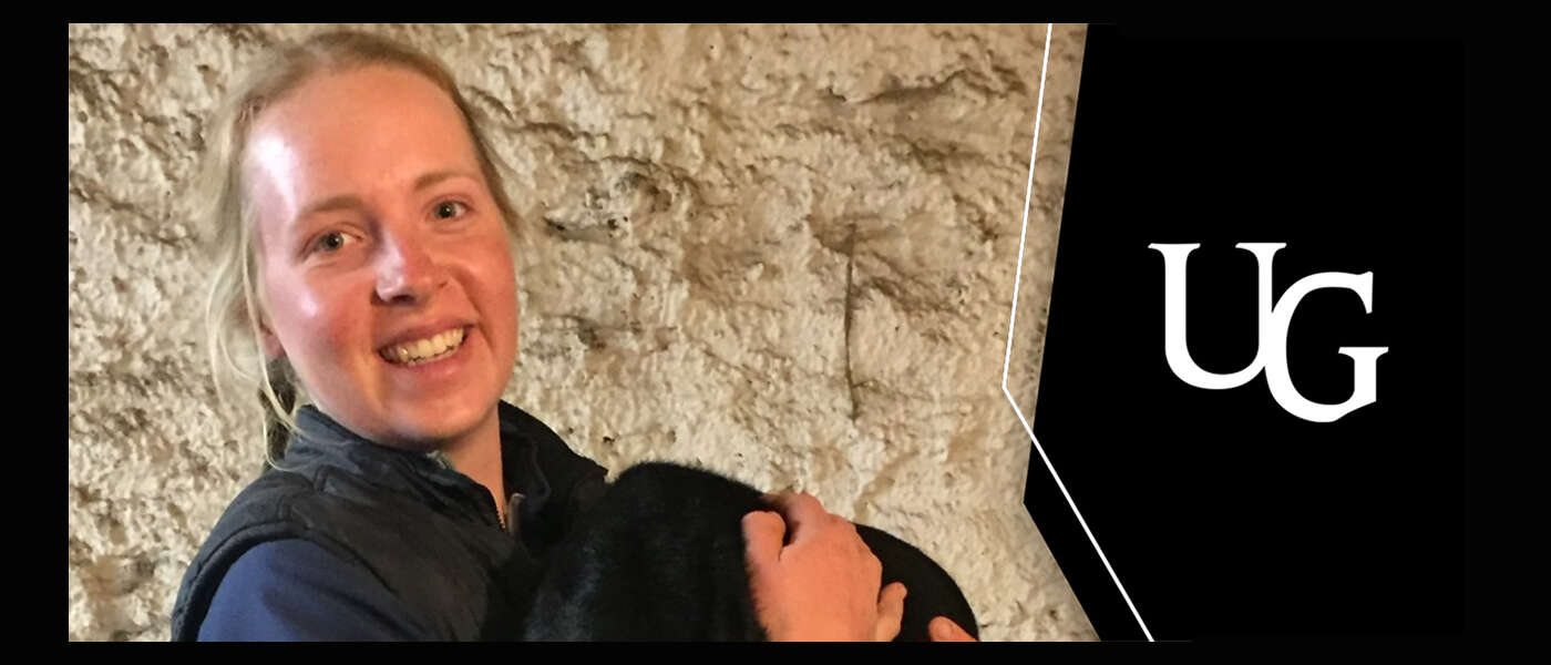 A smiling Allison Visser against a stone wall