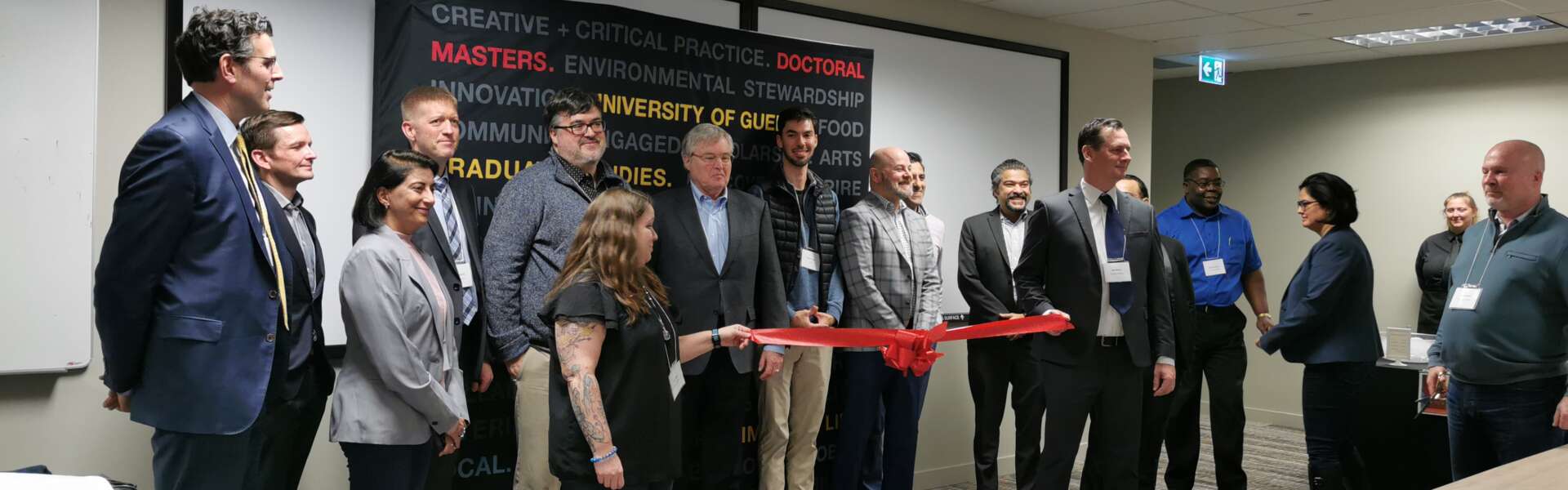 Attendees hold the ceremonial red ribbon at the opening of the MCTI cyber space.