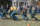 Participants pull on a rope during a tug-a-war competition outdoors while onlookers watch from behind