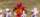a football player in a red Gryphons uniform surveys the fiedl with other players behind him