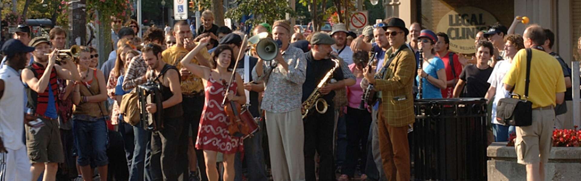 A crowd gathers around a jazz band standing on a street corner in Guelph, Ont.
