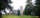 Three people walk across the lawn of Johnston Green on sunny day