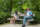 A man and a woman sitting on a park bench, talking.