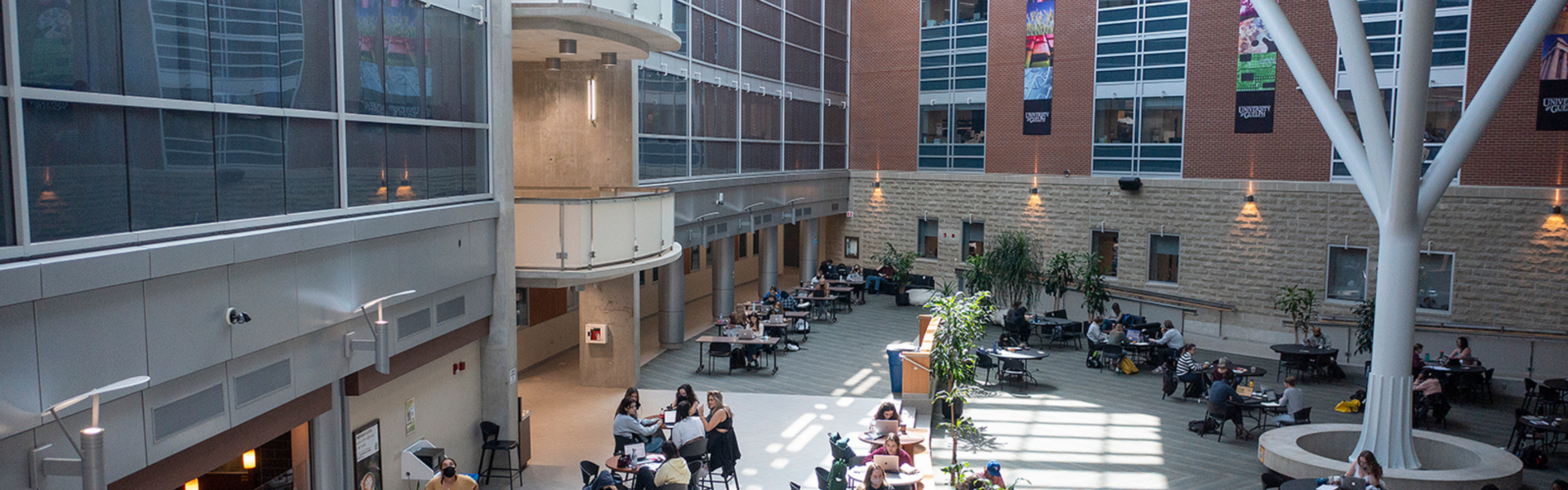 Inside the courtyard of the Summerlee Science Complex as students work at tables.
