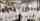 A group of 20 people in lab coats pose for a portrait while standing in a machinery area