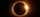 Eclipse in a dark sky, sunlight peeking behind a dark circular object