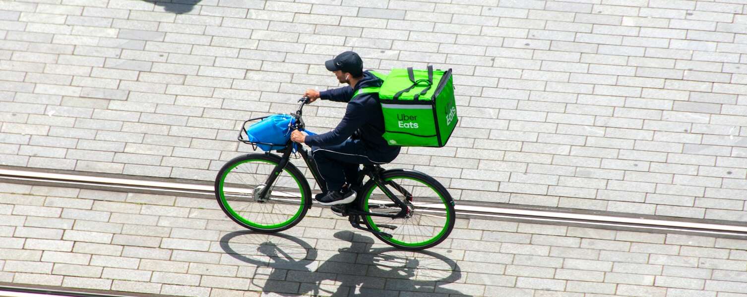 A man riding a bike down a street.