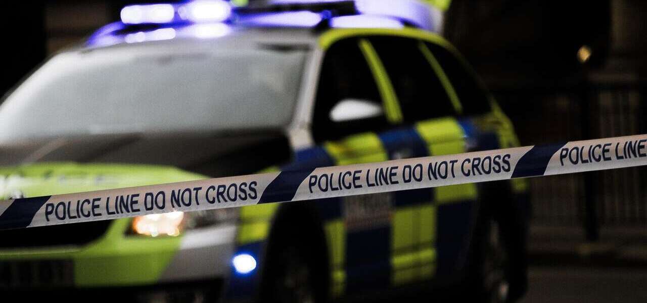 police car with police tape in the foreground