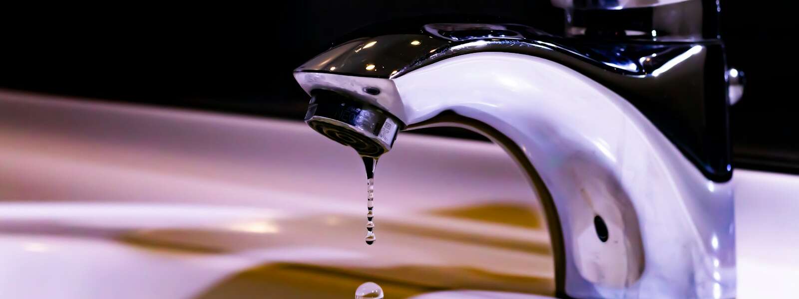 stainless steel faucet on white ceramic sink