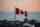 A Canadian flag against an urban background at dusk