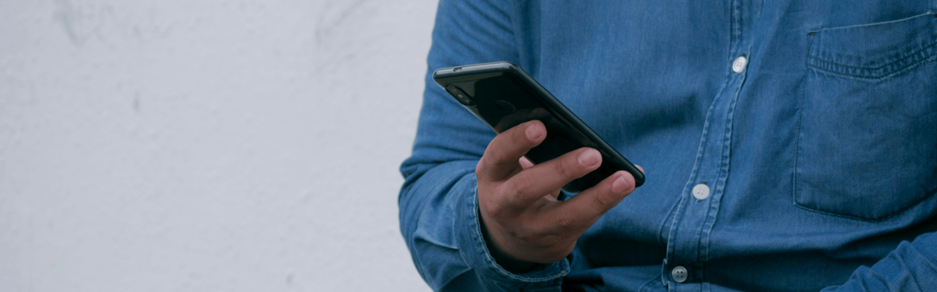 Person holding a smartphone. No visible faces can be seen.