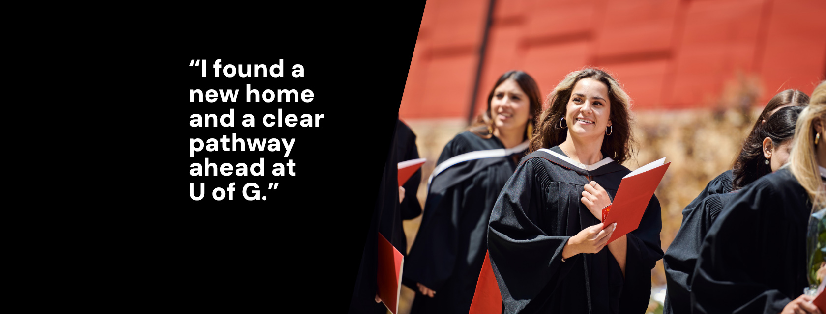 A group of University of Guelph graduates in black gowns smile while holding red diploma folders. They are outdoors in front of a red building. On the left side of the image, bold white text reads: “I found a new home and a clear pathway ahead at U of G.”