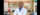 Dr.  Biniam Kebede wears a lab coat and poses for a photo in his lab