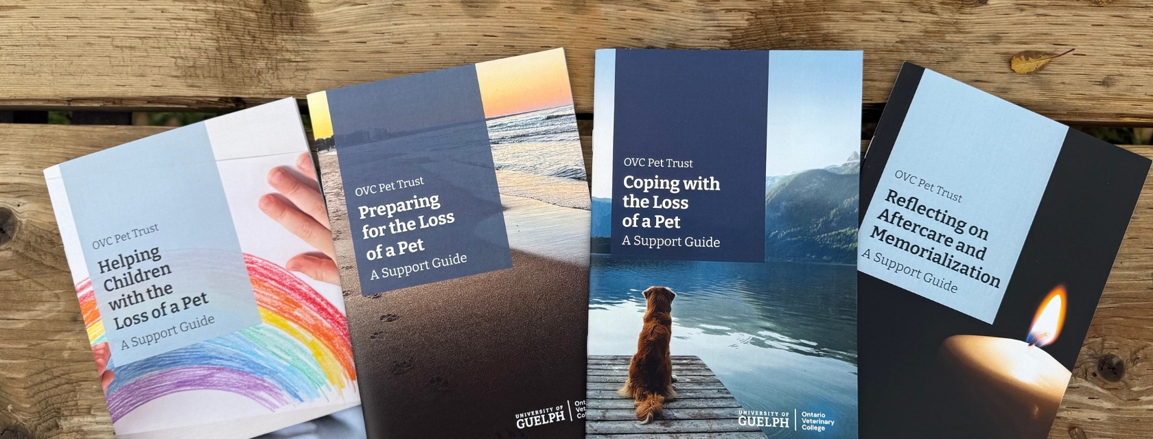 Four OVC Pet Trust grief guides on pet loss displayed on wooden table.