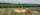 drone with four legs on a launch pad in front of a field