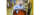 person in lab coat and hairnet holds a sensor near a vat filled with peppers and liquid