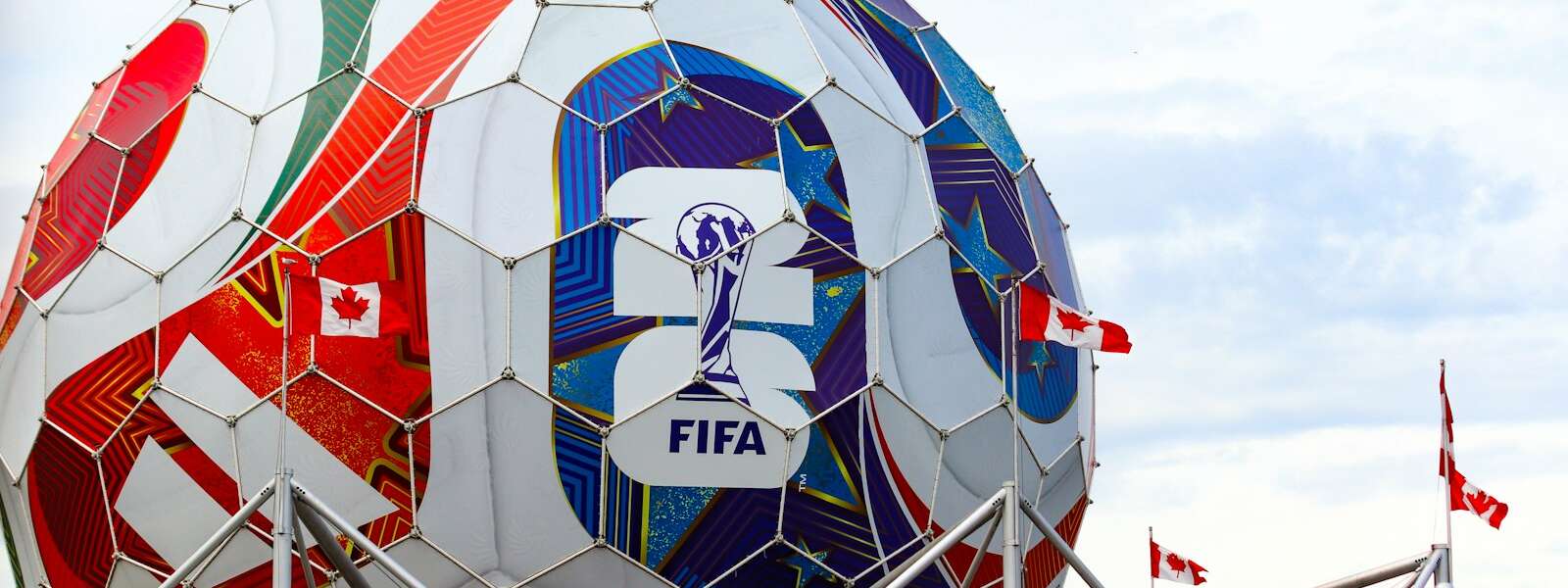 A giant colorful fifa soccer ball structure with canadian flags.